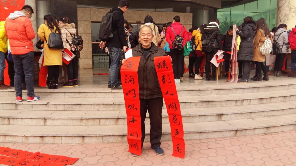 社区居民高兴地展示拿到的春联